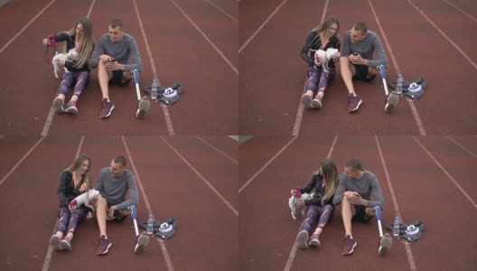 一对运动夫妇在跑道上和他们的狗玩耍高清在线视频素材下载