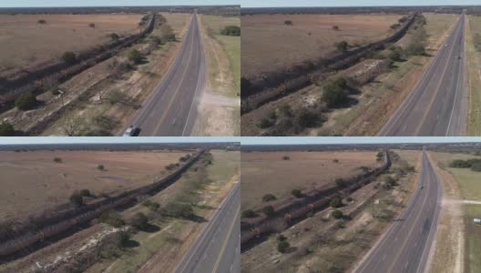 美国德克萨斯州爱德华兹高原上的一列货运火车正沿着一条高速公路行驶在稀树草原上。无人机用摄像机向前移动视频，跟踪列车。高清在线视频素材下载