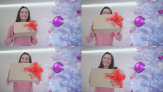 模糊的时光流逝，妈妈多么开心，在圣诞树下找到了一份送给自己的礼物，把它伸到相机前，满怀感激之情。高清在线视频素材下载