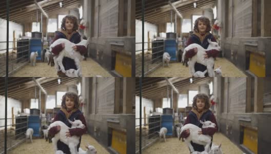 小男孩抱着小山羊站在牲口棚里高清在线视频素材下载