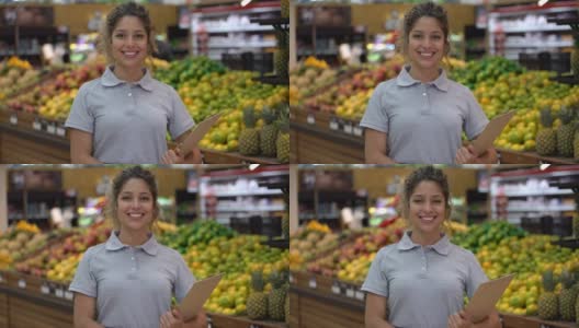 美丽的年轻女售货员在超市拿着一个剪贴板，而面对镜头微笑高清在线视频素材下载