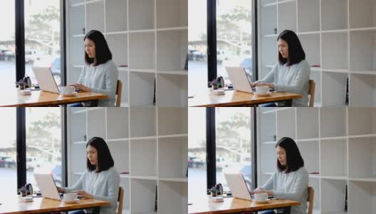 年轻女子在图书馆用笔记本电脑工作，喝着热咖啡高清在线视频素材下载