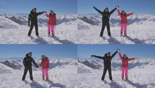 快乐的滑雪情侣站在山顶，举起手高清在线视频素材下载
