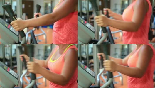 女人在健身房的步进机上训练。健康和健身的概念高清在线视频素材下载