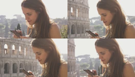 日落时分，在罗马斗牛场前，美丽的年轻女子在她的智能手机上发短信浏览图片高清在线视频素材下载