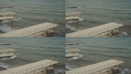 一个女人站在波涛汹涌的海面上高清在线视频素材下载