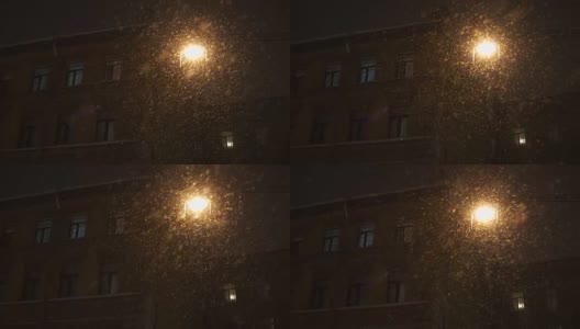 晚上城里下大雪。大朵雪花照亮灯落高清在线视频素材下载