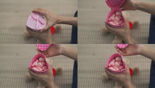 女人的手打开礼品盒，粉红色的棉花糖，心形高清在线视频素材下载