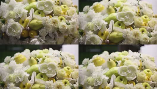 一束美丽的鲜花和水果。特写镜头。用白花组成苹果和梨。高清在线视频素材下载