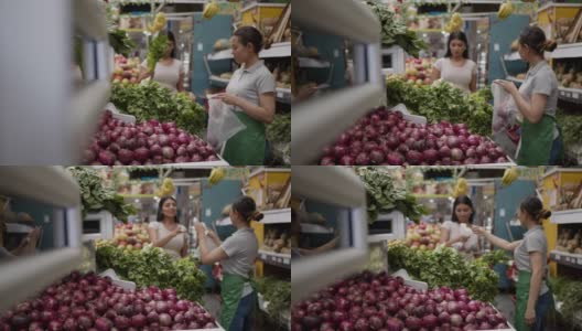 友善的女售货员用一个装着洋葱的塑料袋帮顾客挑选洋葱高清在线视频素材下载
