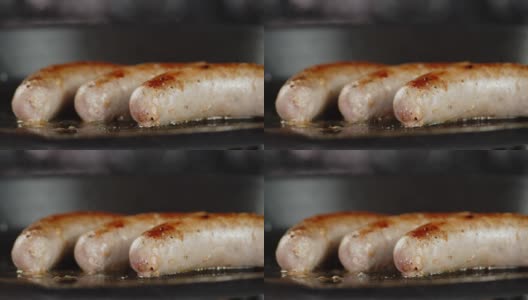 香肠在煎锅里用油煎。高清在线视频素材下载