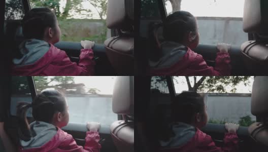 4K亚洲小女孩在车里找东西。早上，女孩在上学的路上看着车窗外的东西。孩子们在车里可以看到街景，放松心情。家庭在汽车概念。高清在线视频素材下载
