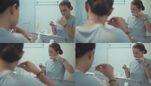 女人在浴室里刷牙和使用智能手机高清在线视频素材下载