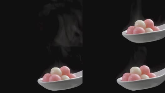 新鲜而热的汤圆汤圆包在白色的汤勺上，黑色的背景。高清在线视频素材下载