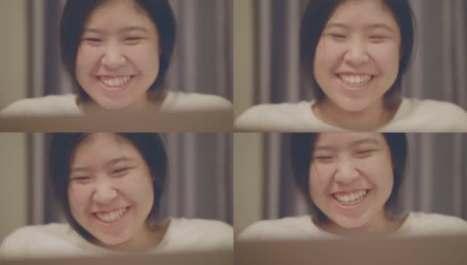 亚洲妇女看着笔记本电脑，笑得很开心高清在线视频素材下载