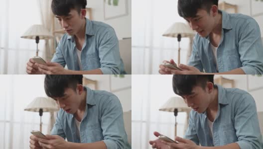 一名困惑的亚洲男子在家中客厅查看手机上令人震惊的通知信息时，手掌向上看着屏幕的特写镜头。高清在线视频素材下载