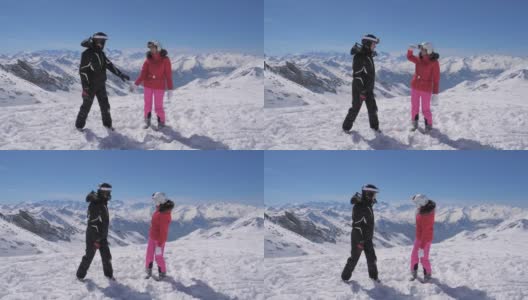 一对快乐的滑雪者站在山顶向后看高清在线视频素材下载