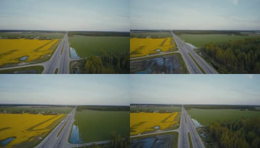 高速公路在平原与森林和油菜田。无人机4K旋转拍摄。农作物产业物流高清在线视频素材下载