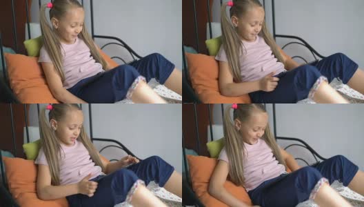 小女孩在家里玩数码平板电脑。高清在线视频素材下载