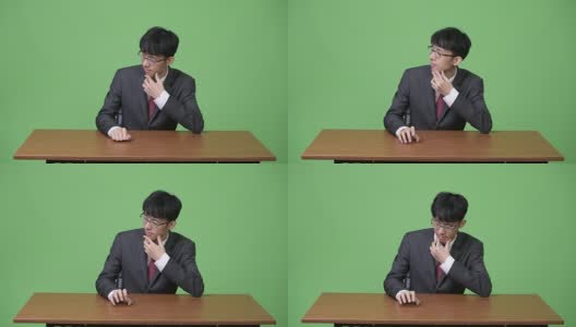 年轻的亚洲商人无聊地用手指敲着桌子高清在线视频素材下载