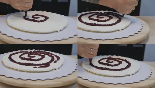 把浆果汁涂在第一个薄薄的海绵蛋糕上，再加上奶油，做成一个大蛋糕高清在线视频素材下载