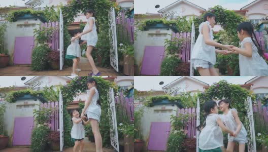 慢动作2个亚洲中国年轻的姐妹手牵着手在房子的前院跳跃在周末的晚上一起欢笑的时间高清在线视频素材下载