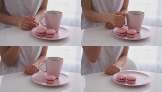 年轻的白人女人在白色的厨房里喝着粉红色的杏仁饼干高清在线视频素材下载