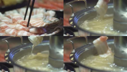 牛肉生肉用筷子夹住。火锅与甜甜圈形状的黄铜锅。高清在线视频素材下载