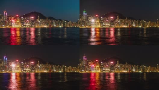 4K城市时间推移广角拍摄的摩天大楼城市景观商业建筑塔与灯光和水运船船通过海湾在晚上在中国香港的海湾。高清在线视频素材下载