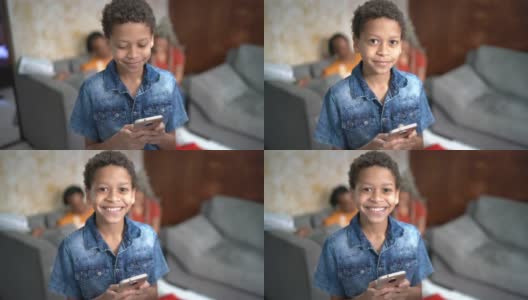 一个男孩在家里使用手机的肖像高清在线视频素材下载
