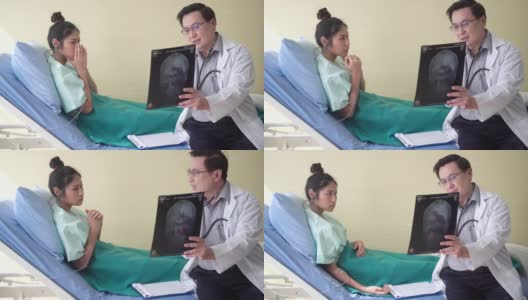 医生正在解释头部x光扫描图。病人感到震惊和悲伤。高清在线视频素材下载