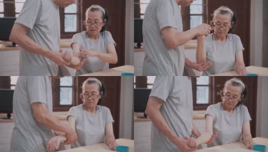 老年女性与成年男性在家做手臂理疗高清在线视频素材下载