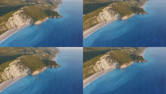 鸟瞰希腊爱奥尼亚岛美丽的米洛斯海滩和Lefkada的海岸线。日落金色的阳光和蓝绿色的大海高清在线视频素材下载
