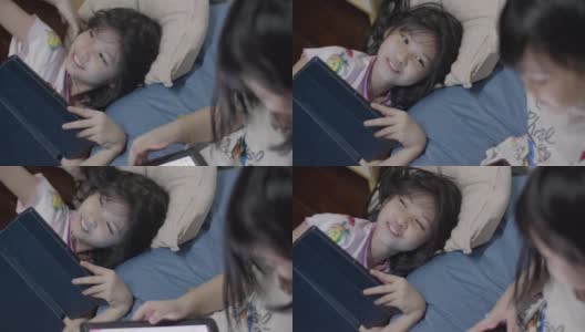 亚洲女孩享受玩你的平板电脑在床上。高清在线视频素材下载