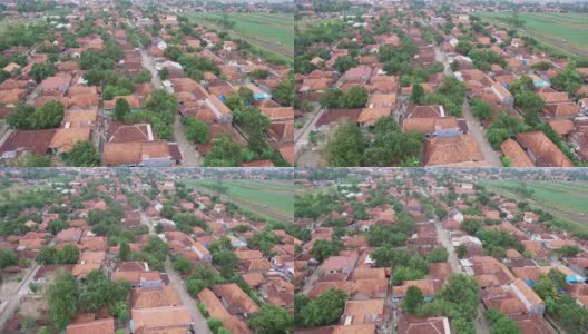 从空中俯瞰一所印尼村庄的房屋，用无人机拍摄，一条道路穿过村庄，旁边是广阔的稻田高清在线视频素材下载