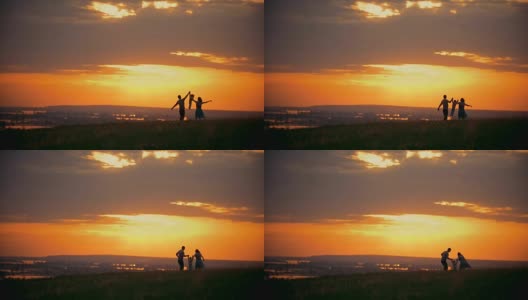 橘黄色的夕阳下一家人与一个小男孩手牵着手休息在大自然中高清在线视频素材下载