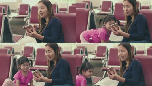 亚洲年轻的母亲和女儿在候机楼登机口用智能手机等待高清在线视频素材下载