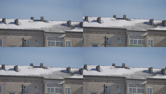 雪躺在一个多层老房子的屋顶冬季城市的户外景色高清在线视频素材下载