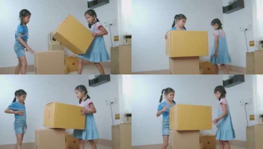 在搬家日，两个亚洲女孩帮助父母在搬家前准备盒子里的东西。家居装修和搬迁概念。慢动作镜头。高清在线视频素材下载