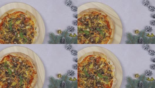 平铺的披萨在木托盘上360度旋转，围绕圣诞装饰高清在线视频素材下载