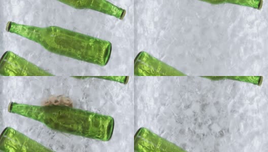 一个女人的手从一个冰容器中拿出一个绿色的啤酒瓶高清在线视频素材下载