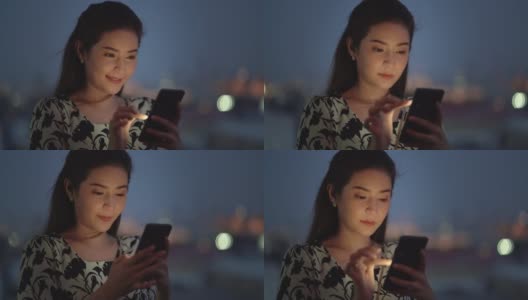 CU:迷人的亚洲女人在晚上使用手机。高清在线视频素材下载