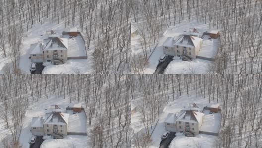 在一场冬季暴风雪后被雪覆盖的乡村社区的住宅。一辆车停在刚清理过的车道上。空中无人机视频。高清在线视频素材下载