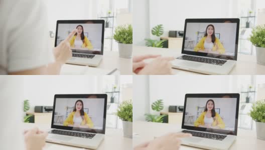 亚洲女商人使用笔记本电脑与同事在视频电话会议的计划，而工作在家里的客厅。高清在线视频素材下载