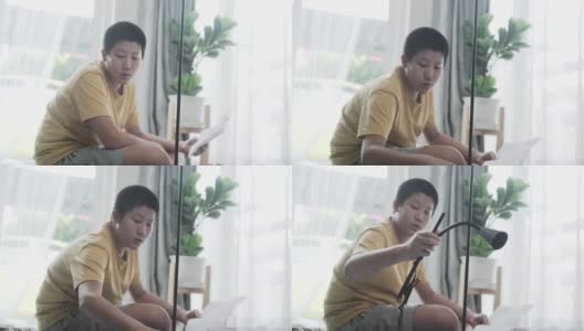 亚洲男孩在家组装从网上买的新电灯，男孩自己打结。高清在线视频素材下载