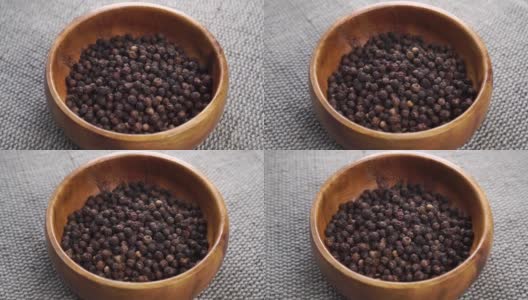 干黑胡椒粒装在木碗里，放在黄麻粗麻袋上高清在线视频素材下载
