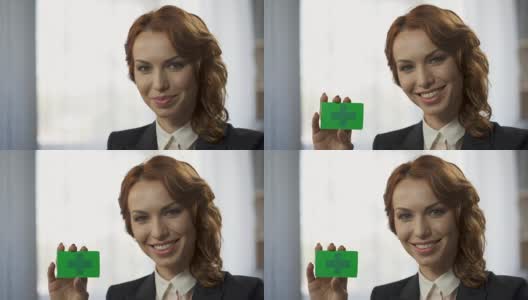 微笑的少妇手里拿着绿色的彩卡，全新便捷的服务高清在线视频素材下载