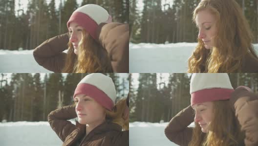 一个美丽的年轻女子在一个下雪的日子戴着一顶无檐帽的侧面照片高清在线视频素材下载