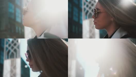 在明亮的阳光下，一个戴着眼镜的女孩的肖像用她的手拉直了她华丽的金发，背景是一个繁忙的城市。特写,时尚高清在线视频素材下载