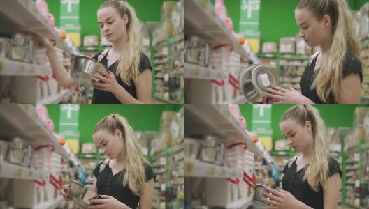 年轻的家庭主妇正在超市挑选金属板高清在线视频素材下载